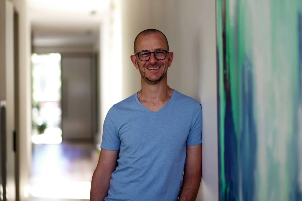 Marc Wiesner smiling in a bright hallway